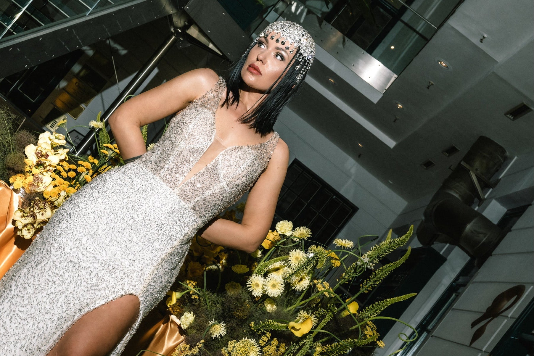 Moderne Braut in glitzerndem Kleid mit Blumenarrangement von Zanoza
