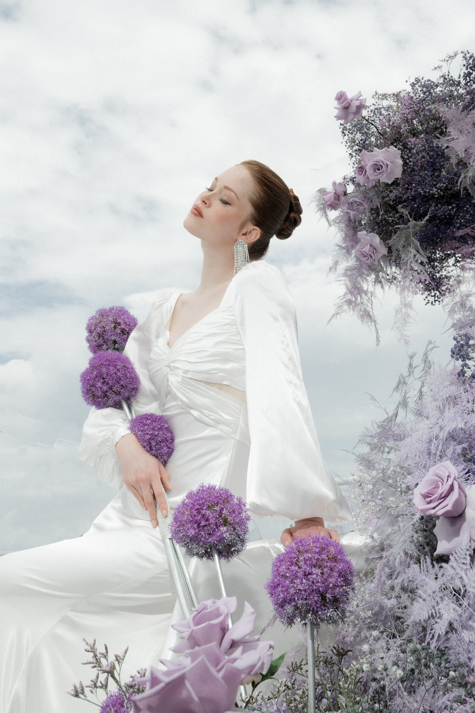 Braut posiert mit Allium lila Blumen am Hochzeitstag