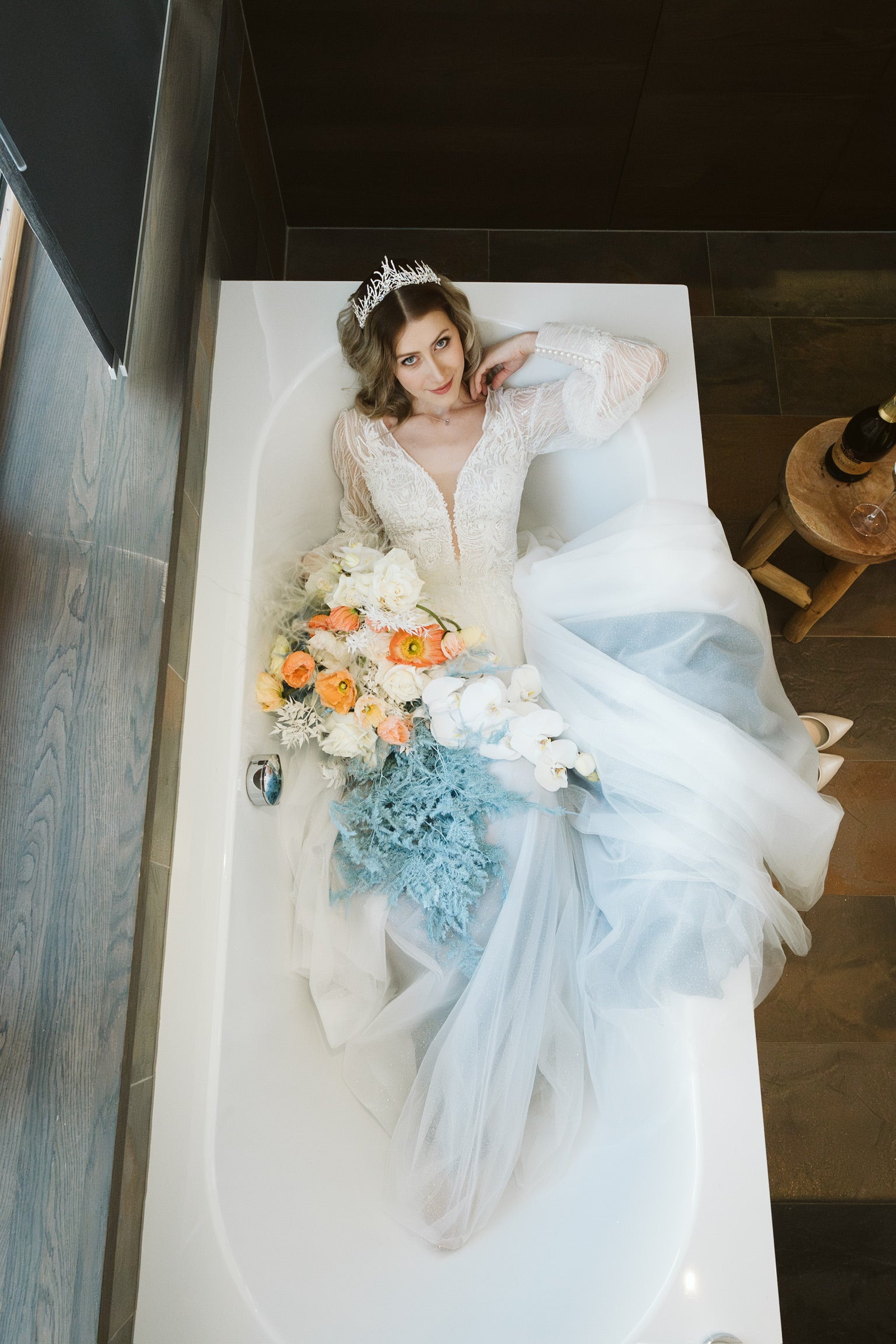 Brautshooting in Badewanne mit Blumenstrauss in den Farben weiss, orange, blau