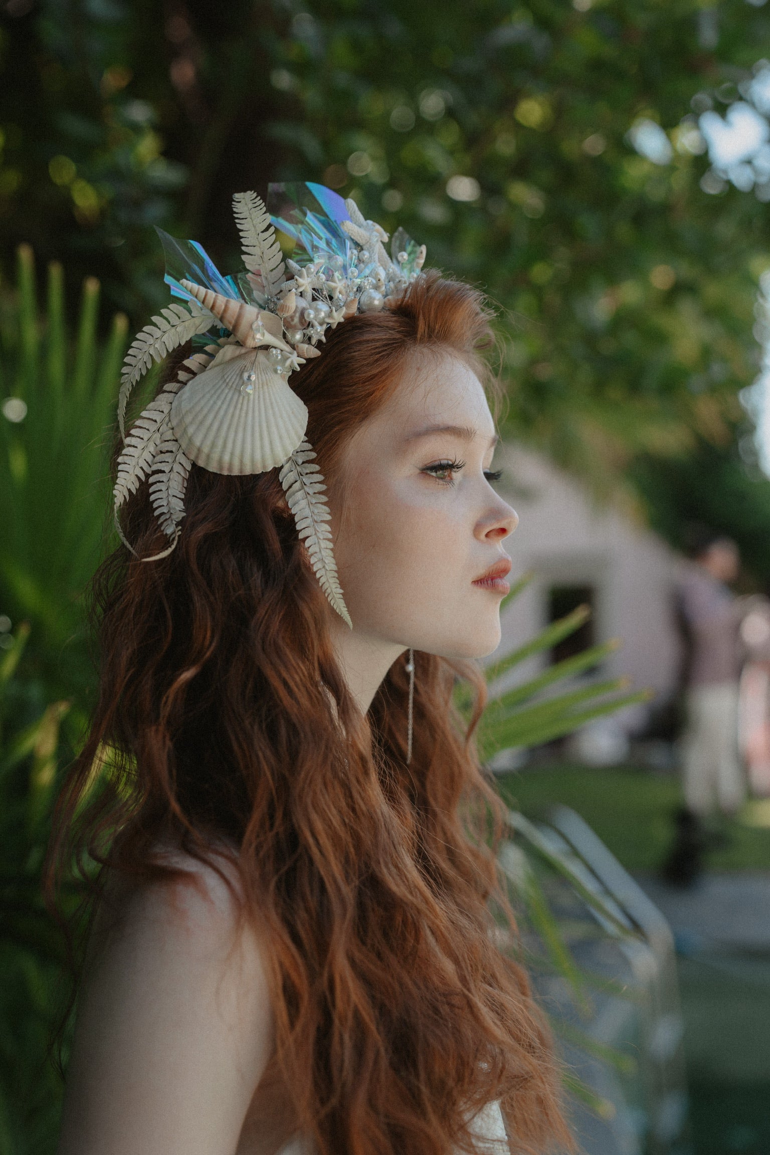 Braut mit Kopfschmuck Blumenkrone mit Muscheln, Federn und Perlen. Elegantes, modernes und außergewöhnliches Hochzeitsthema für Strandhochzeit