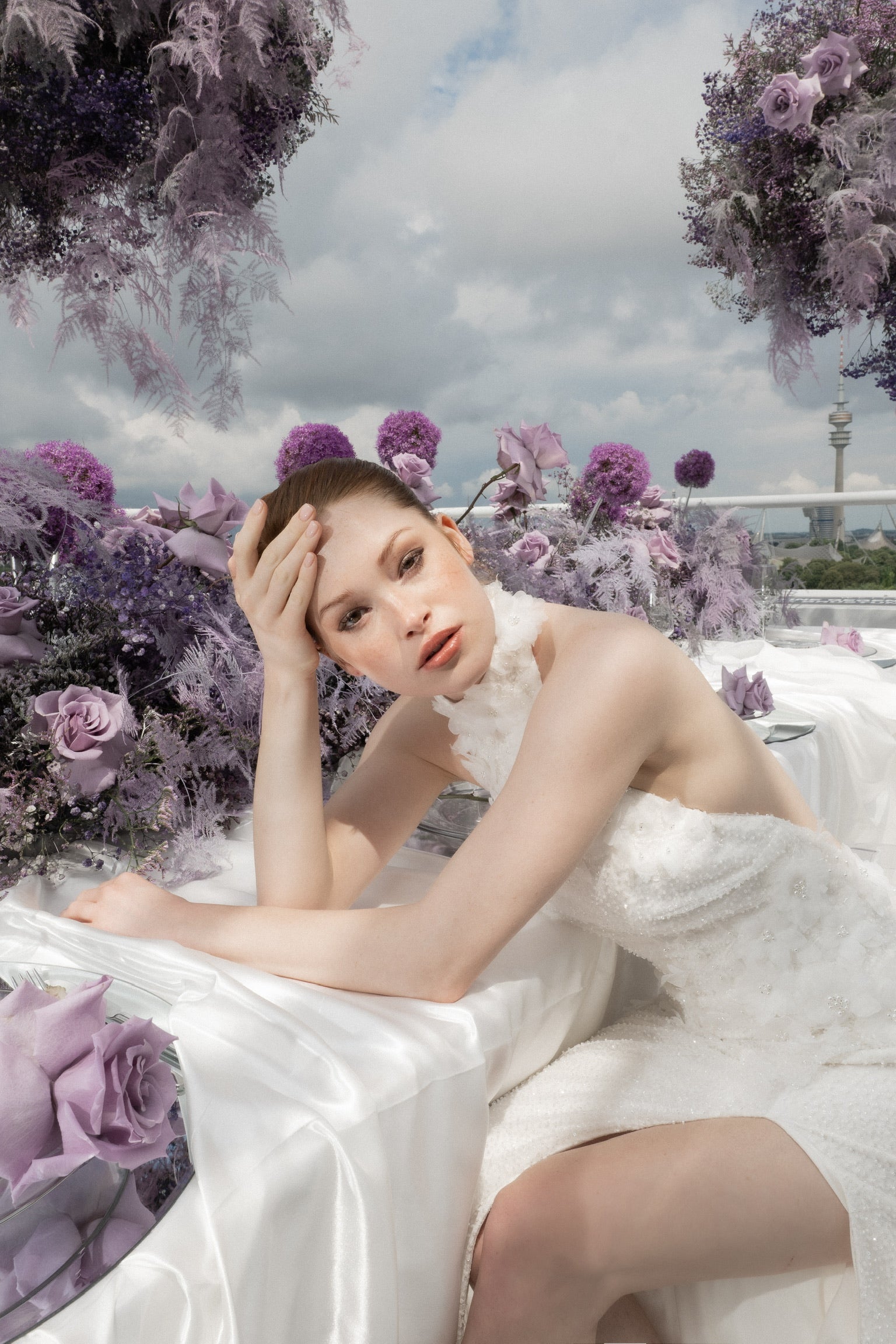 Braut posiert am Hochzeitstisch mit aussergewöhnlicher Tischdekoration von ZANOZA m Farbschema weis-lila-violett