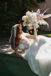Elegantes Brautshooting mit Blumenkomposition aus hellen Blumen, Perlen, Muscheln von Zanoza
