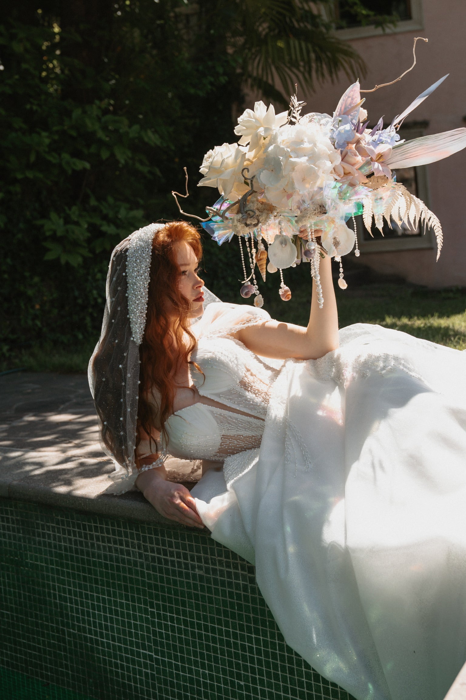 Elegantes Brautshooting mit Blumenkomposition aus hellen Blumen, Perlen, Muscheln von Zanoza
