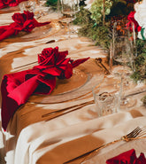 Tischdekoration von ZANOZA mit roten Servietten, roten Rosen, goldenem Besteck
