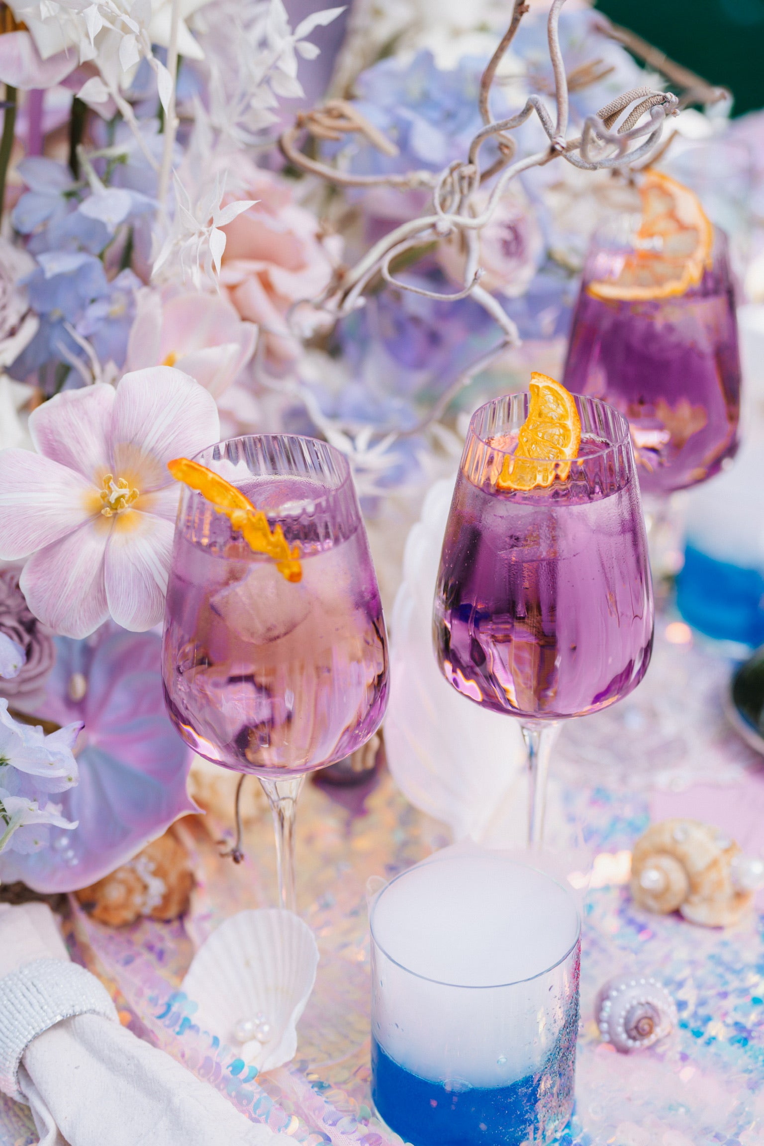 Signature Cockteil für Hochzeit in Lila und blau mit Perlen und Muscheln im Hintergrund