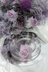 Blumendekoration auf dem Tisch in lila-violett mit Rosen, Allium, Lavendel