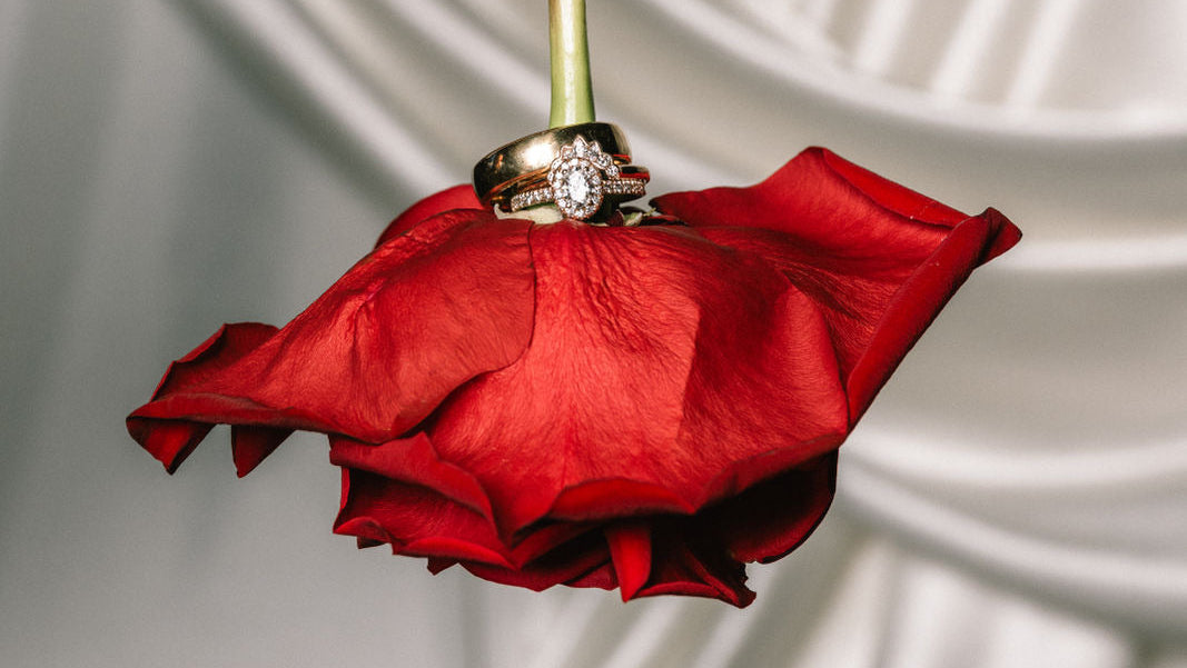 Hochzeitsblumen rote Rose mit Ringen fotografiert
